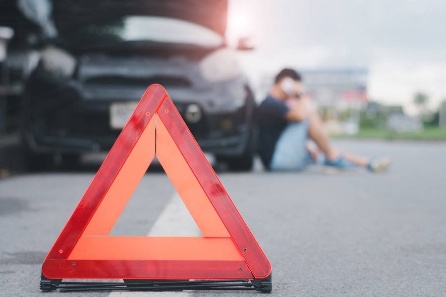 Roadside caution triangle behind a broken-down vehicle
