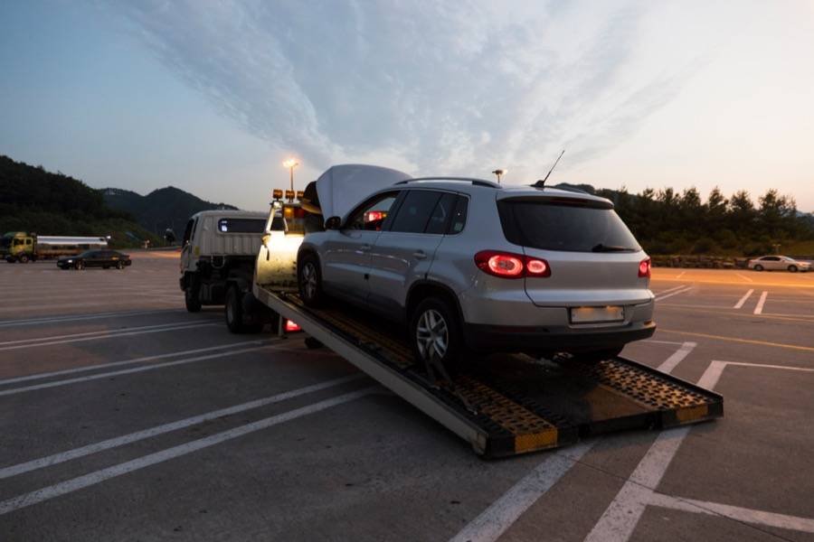 Grey SUV being winched onto a flatbed